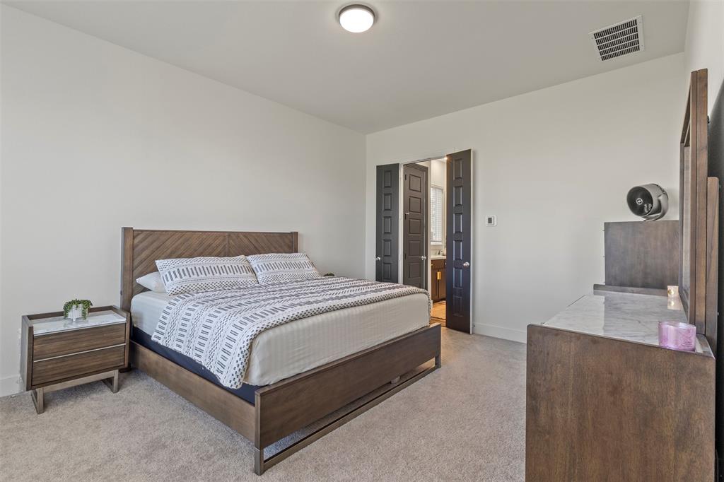 5009 Duck Cv Circle Royse City, TX 75189 - Photo 10 of 34 a spacious bedroom with a bed and a cabinets