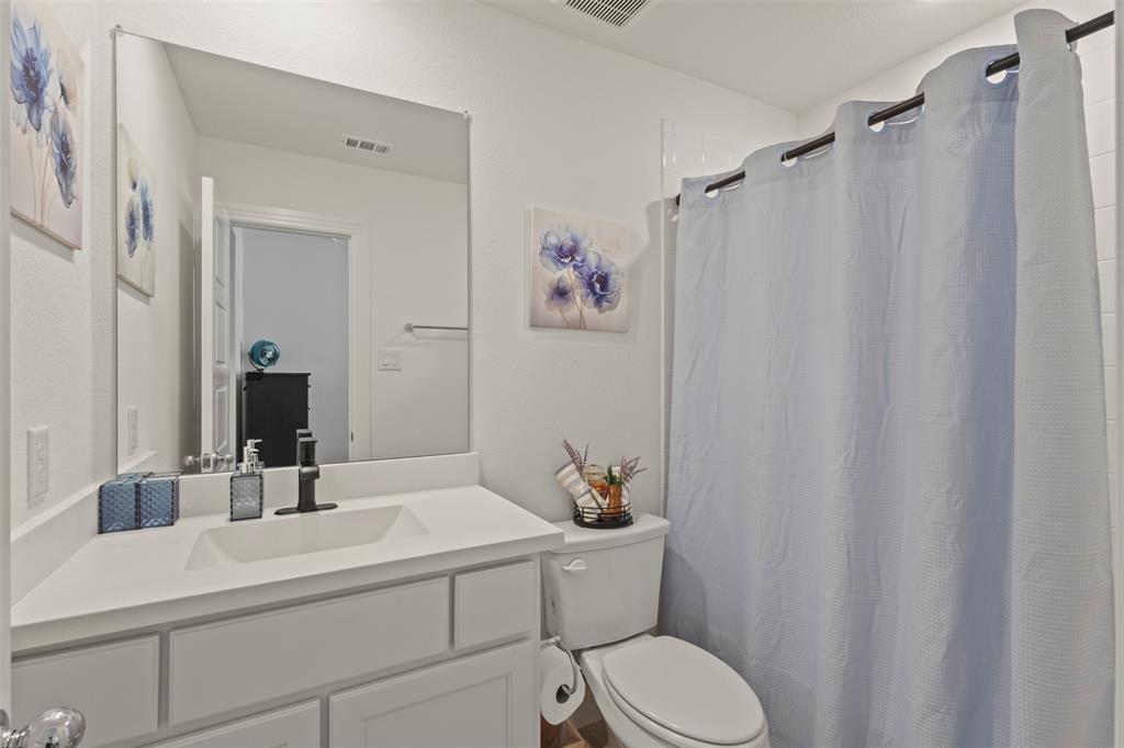 5009 Duck Cv Circle Royse City, TX 75189 - Photo 23 of 34 a bathroom with a sink a toilet and shower curtain