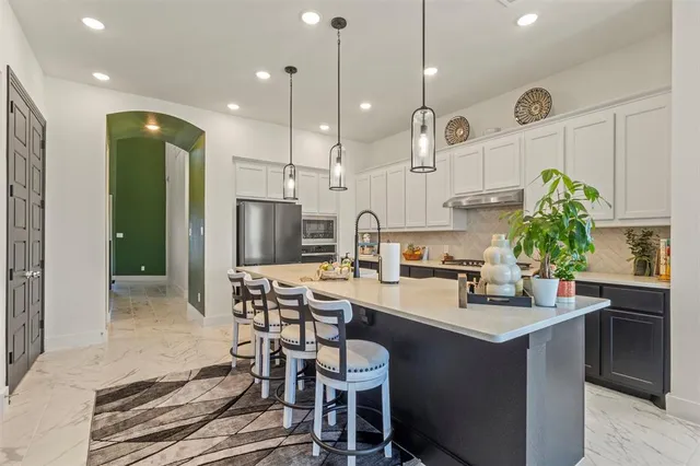 a kitchen with a table chairs refrigerator and microwave