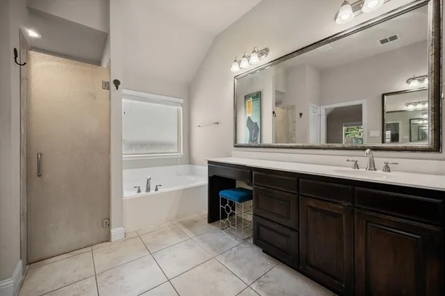 a spacious bathroom with a tub sink and mirror