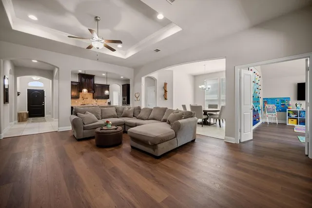 a living room with furniture and a wooden floor