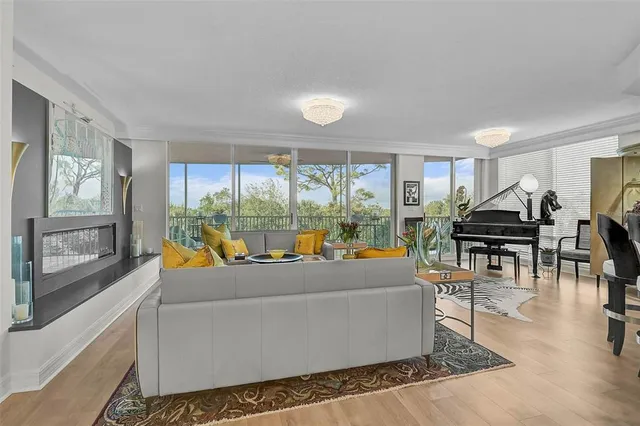 a living room with furniture kitchen view and a wooden floor