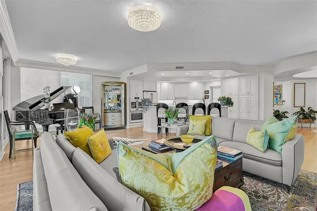 a kitchen with stainless steel appliances a refrigerator a stove a sink white cabinets and chairs with wooden floor