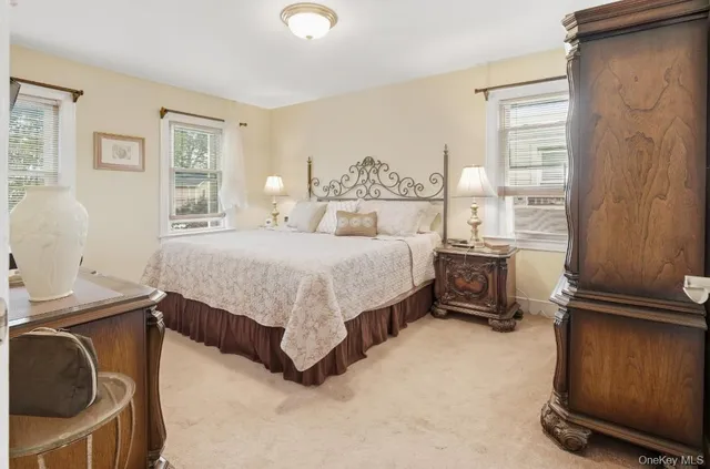 a bedroom with a bed and two windows