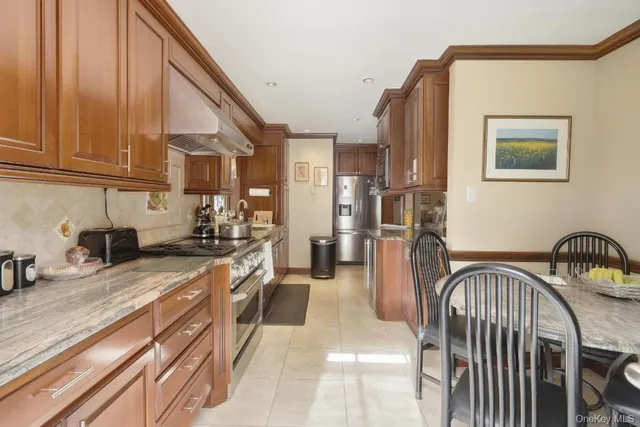 a kitchen with stainless steel appliances granite countertop a refrigerator a stove and a sink with cabinets