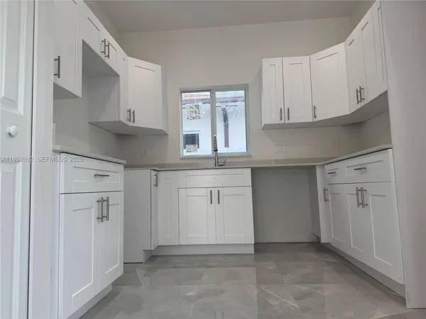 a kitchen with white cabinets and a sink
