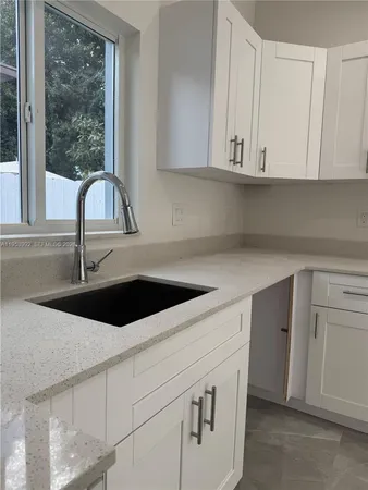 a close view of a sink a microwave and cabinets