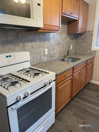 a white stove top oven sitting inside of a kitchen
