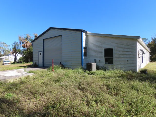 a backyard of a house with wooden fence and large windows