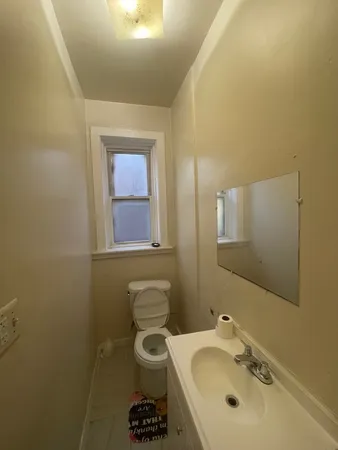 a bathroom with a sink mirror and toilet