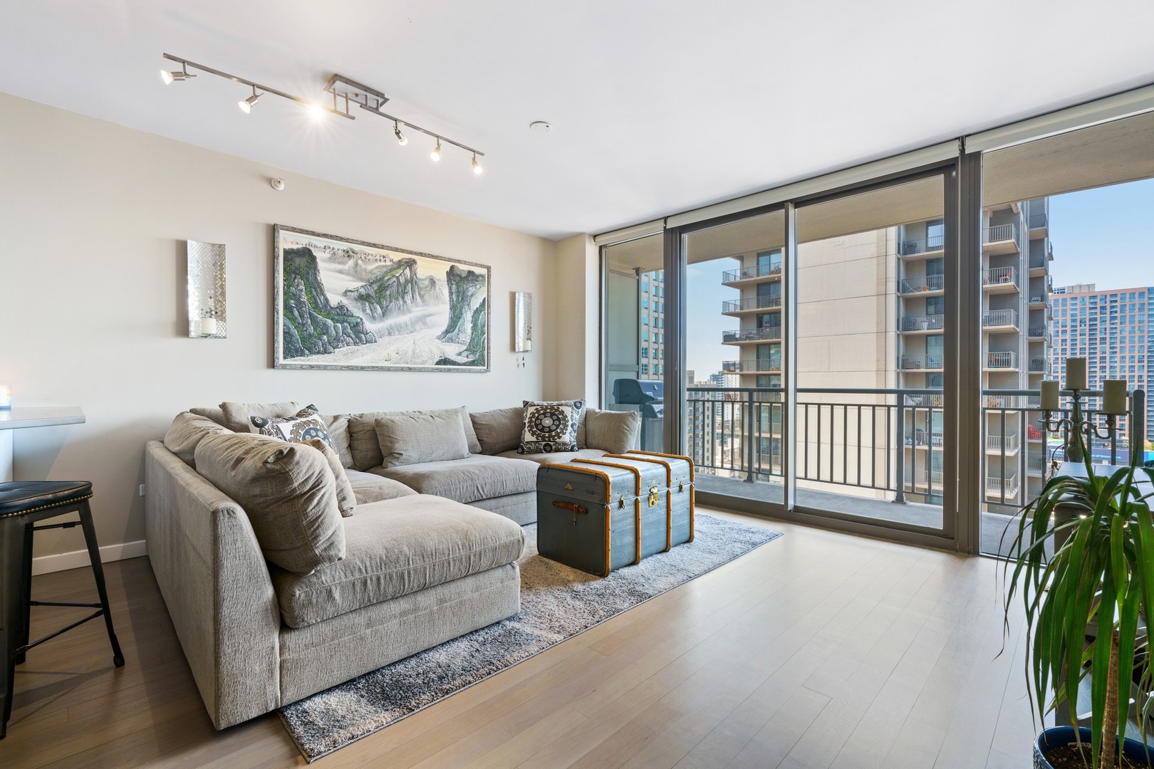 630 North State Street, Unit 2210 Chicago, IL 60654 - Photo 2 of 23 a living room with furniture a flat screen tv and a floor to ceiling window