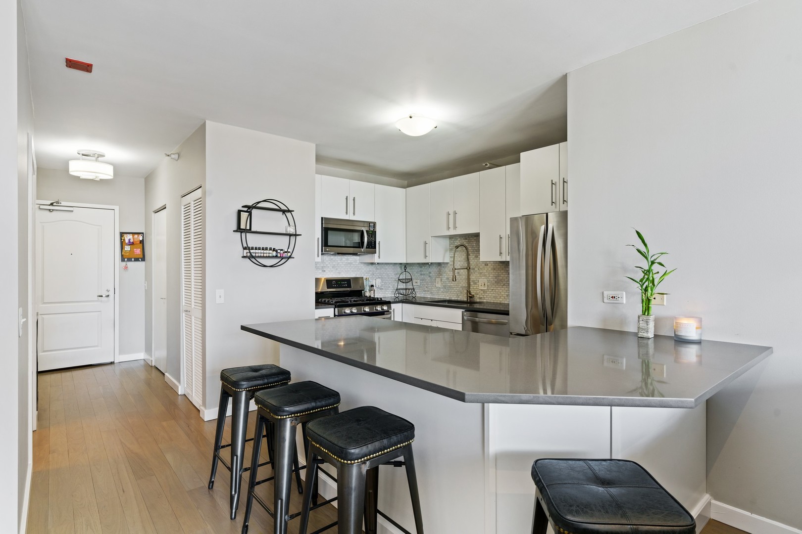 630 North State Street, Unit 2210 Chicago, IL 60654 - Photo 6 of 23 a kitchen with stainless steel appliances a sink a stove a refrigerator cabinets and chairs