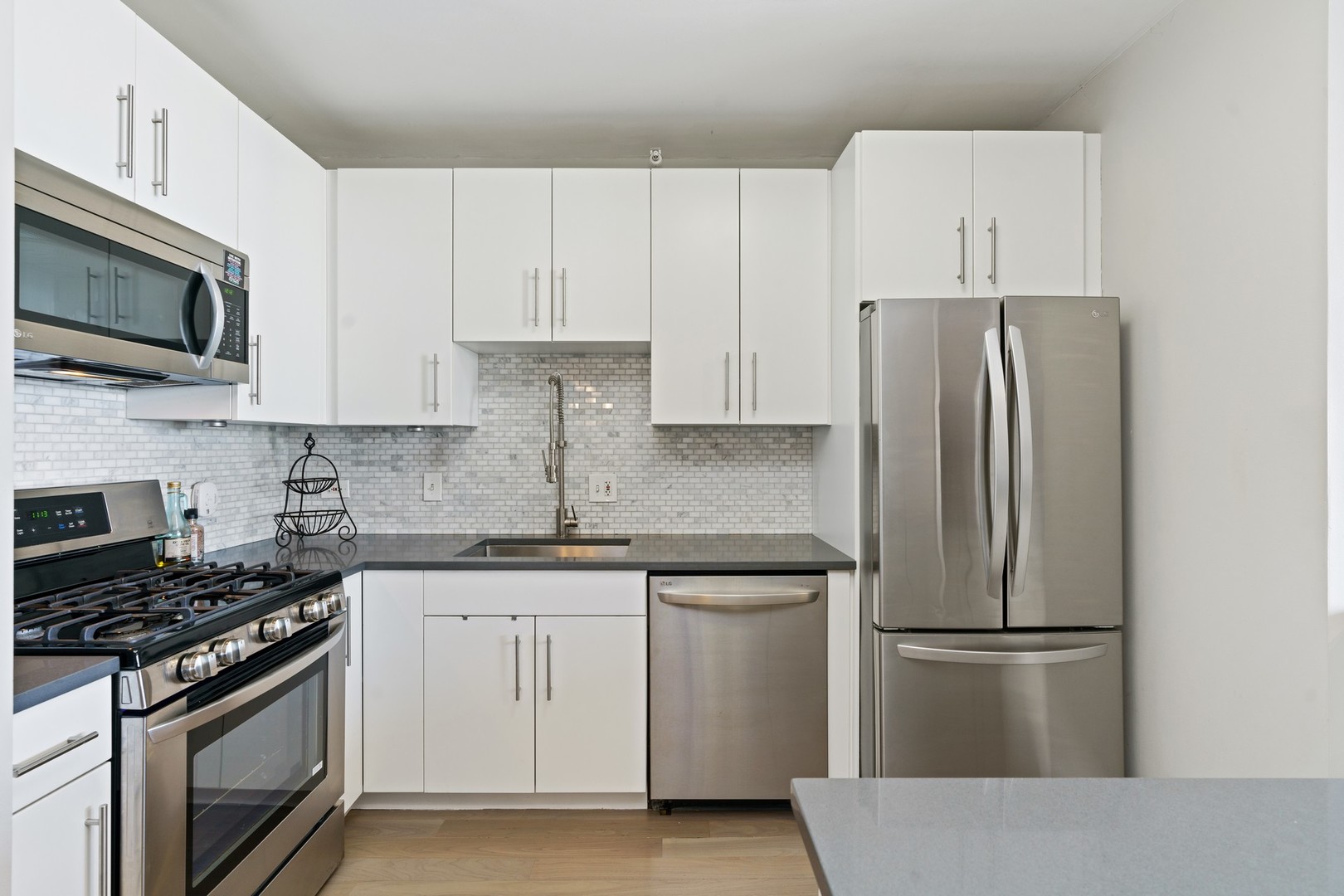 630 North State Street, Unit 2210 Chicago, IL 60654 - Photo 7 of 23 a kitchen with stainless steel appliances white cabinets white stove a microwave and a refrigerator
