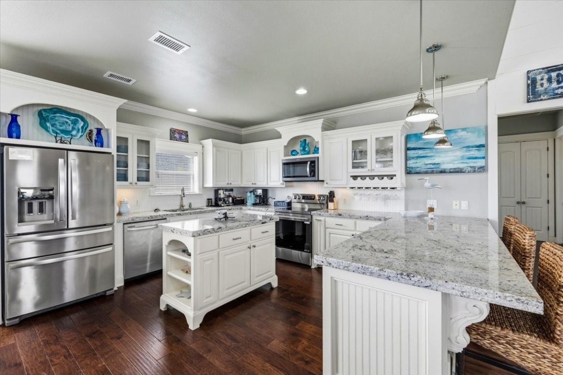 839 Eastview Crystal Beach, TX 77650 - Photo 15 of 44 a kitchen with stainless steel appliances granite countertop a stove refrigerator and cabinets