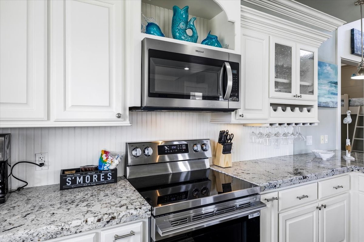 839 Eastview Crystal Beach, TX 77650 - Photo 18 of 44 a kitchen with stainless steel appliances granite countertop a stove a microwave and cabinets