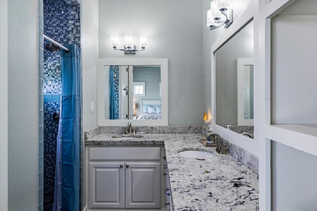 839 Eastview Crystal Beach, TX 77650 - Photo 25 of 44 a bathroom with a granite countertop sink and a mirror