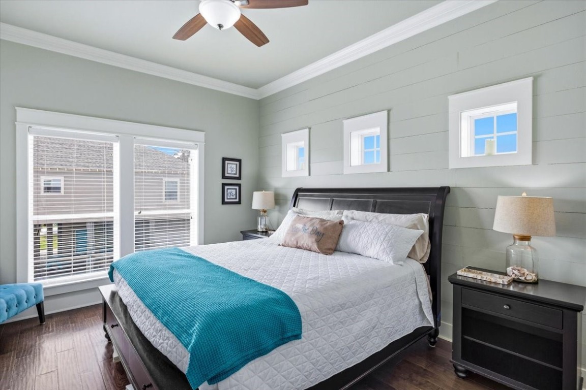 839 Eastview Crystal Beach, TX 77650 - Photo 27 of 44 a bedroom with a bed and a lamp on dresser with wooden floor