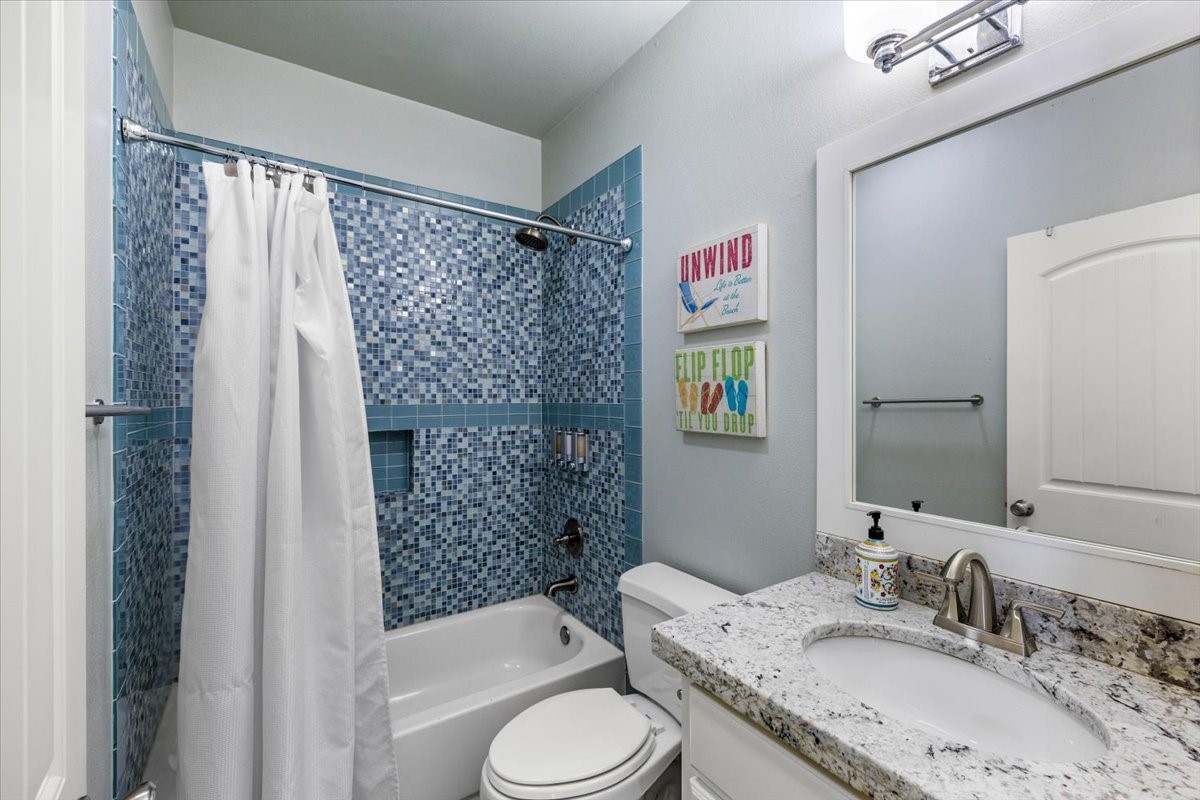 839 Eastview Crystal Beach, TX 77650 - Photo 34 of 44 a bathroom with a granite countertop toilet sink and shower