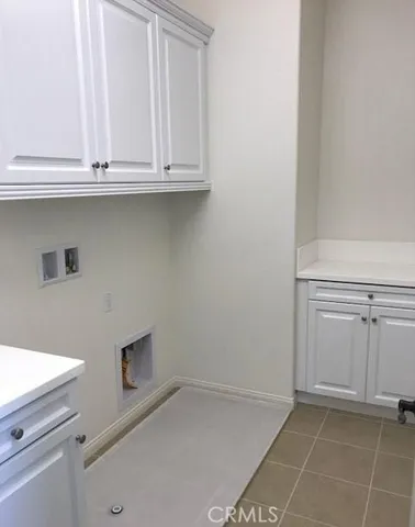 a view of cabinets and utility room with closet