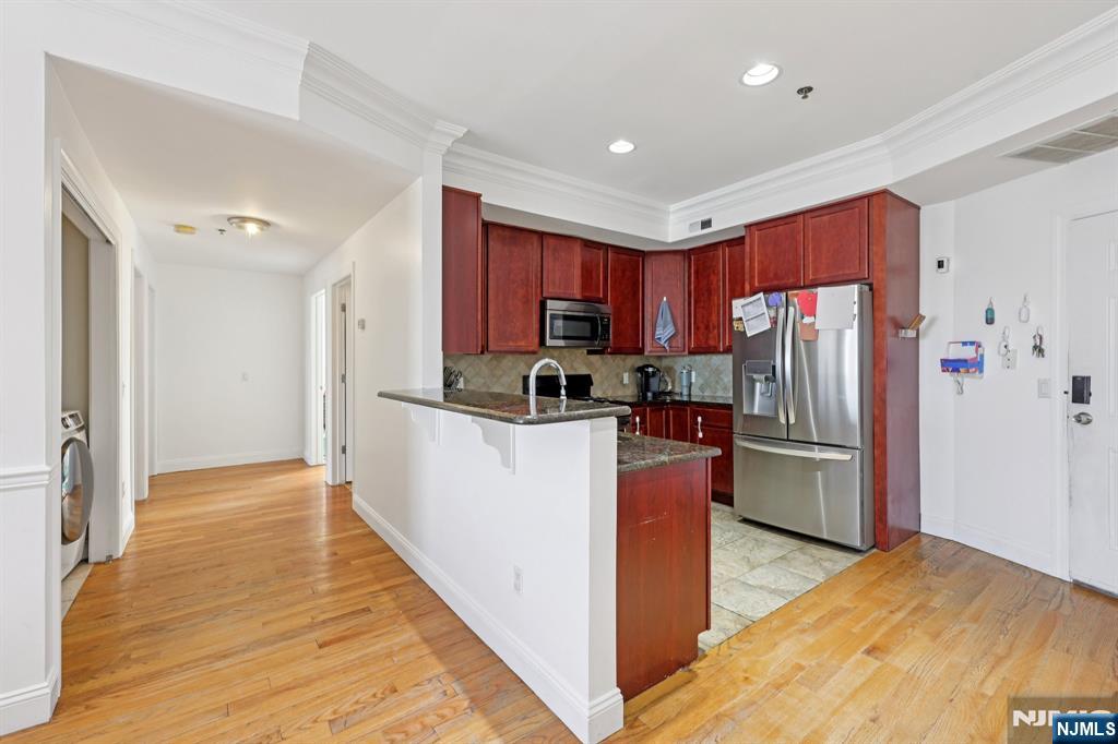 15 Tichenor Street, Unit 407 Newark, NJ 07102 - Photo 14 of 26 a kitchen with stainless steel appliances a refrigerator and a stove top oven