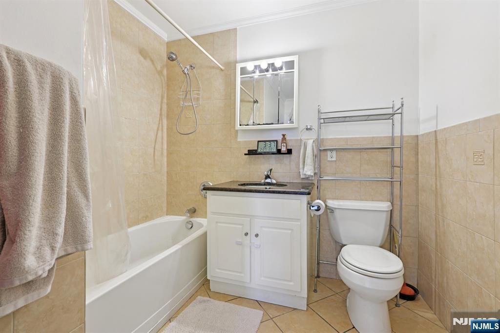 15 Tichenor Street, Unit 407 Newark, NJ 07102 - Photo 16 of 26 a bathroom with a granite countertop toilet a sink and a bathtub