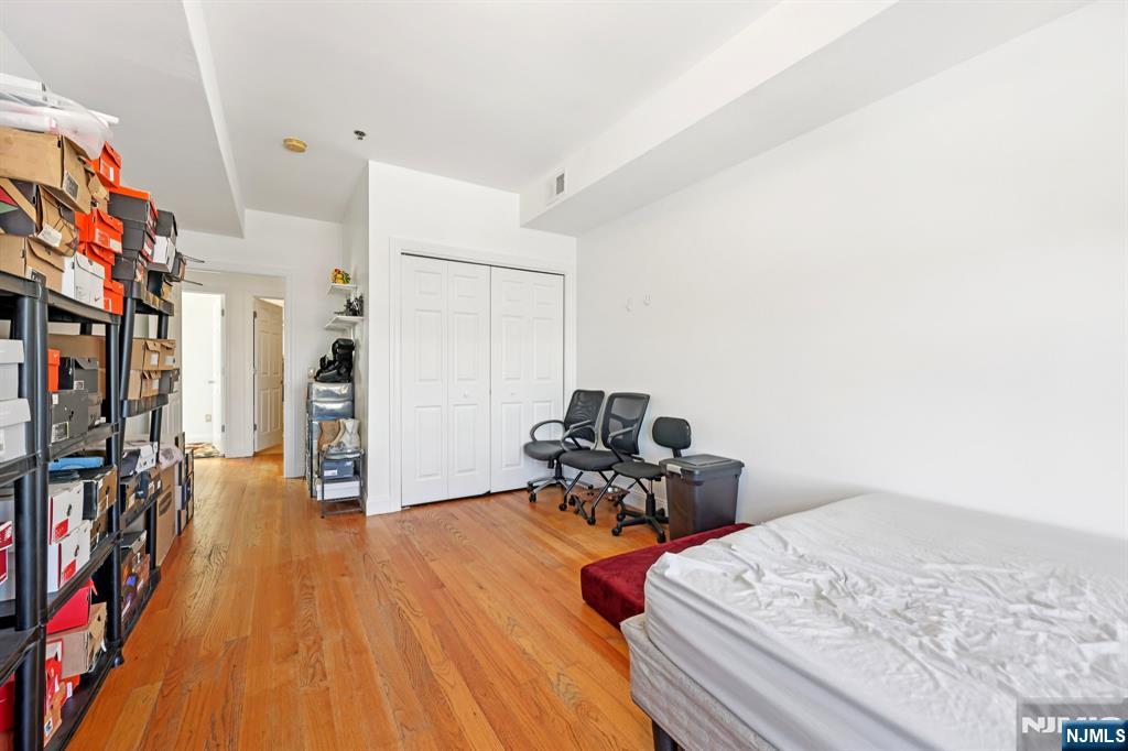 15 Tichenor Street, Unit 407 Newark, NJ 07102 - Photo 18 of 26 a bedroom with furniture and a wooden floor