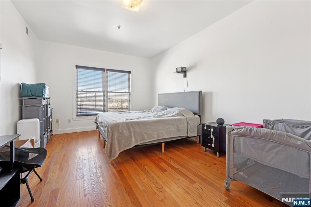 15 Tichenor Street, Unit 407 Newark, NJ 07102 - Photo 21 of 26 a bedroom with a bed and wooden floor