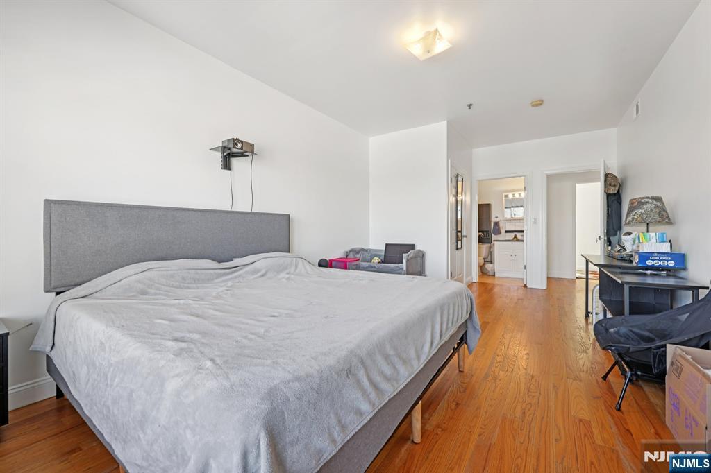 15 Tichenor Street, Unit 407 Newark, NJ 07102 - Photo 22 of 26 a bedroom with bed and wooden floor