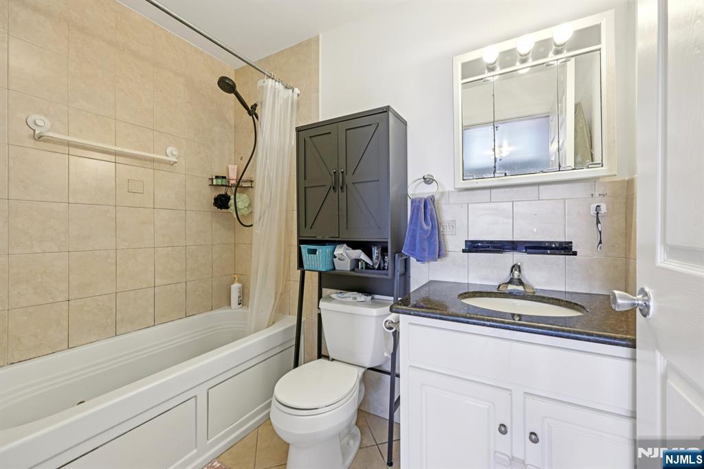 15 Tichenor Street, Unit 407 Newark, NJ 07102 - Photo 23 of 26 a bathroom with a granite countertop sink toilet and shower