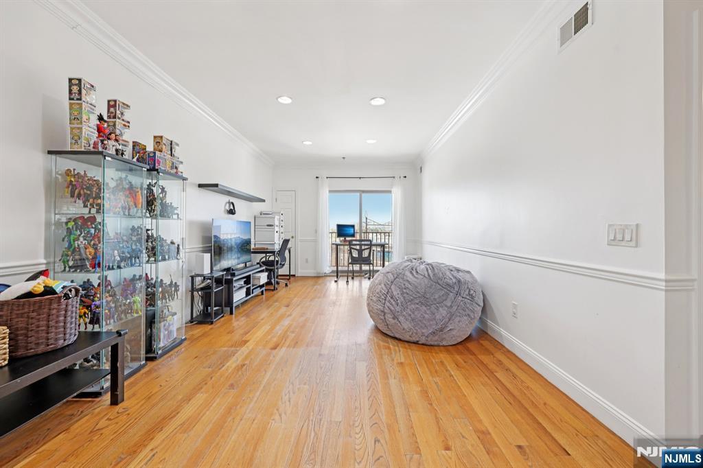 15 Tichenor Street, Unit 407 Newark, NJ 07102 - Photo 7 of 26 a living room with furniture and a wooden floor