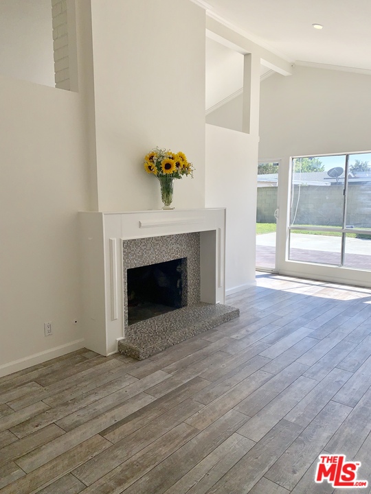 1238 Sultan Circle Carson, CA 90746 - Photo 15 of 18 a view of an empty room with wooden floor and a fireplace