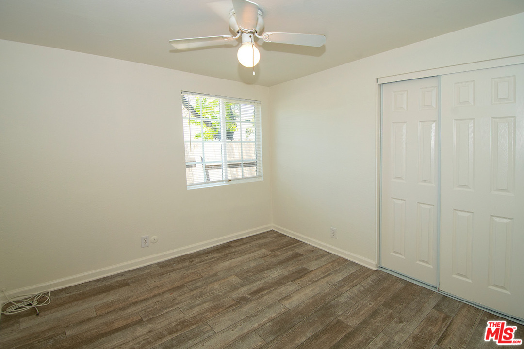 1238 Sultan Circle Carson, CA 90746 - Photo 6 of 18 an empty room with wooden floor ceiling fan and windows