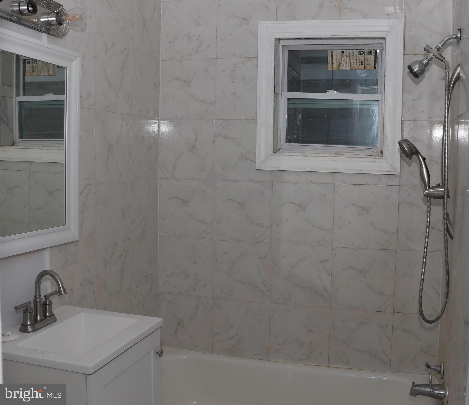 8400 Liberty Road Baltimore, MD 21244 - Photo 11 of 32 a bathroom with a shower sink and mirror