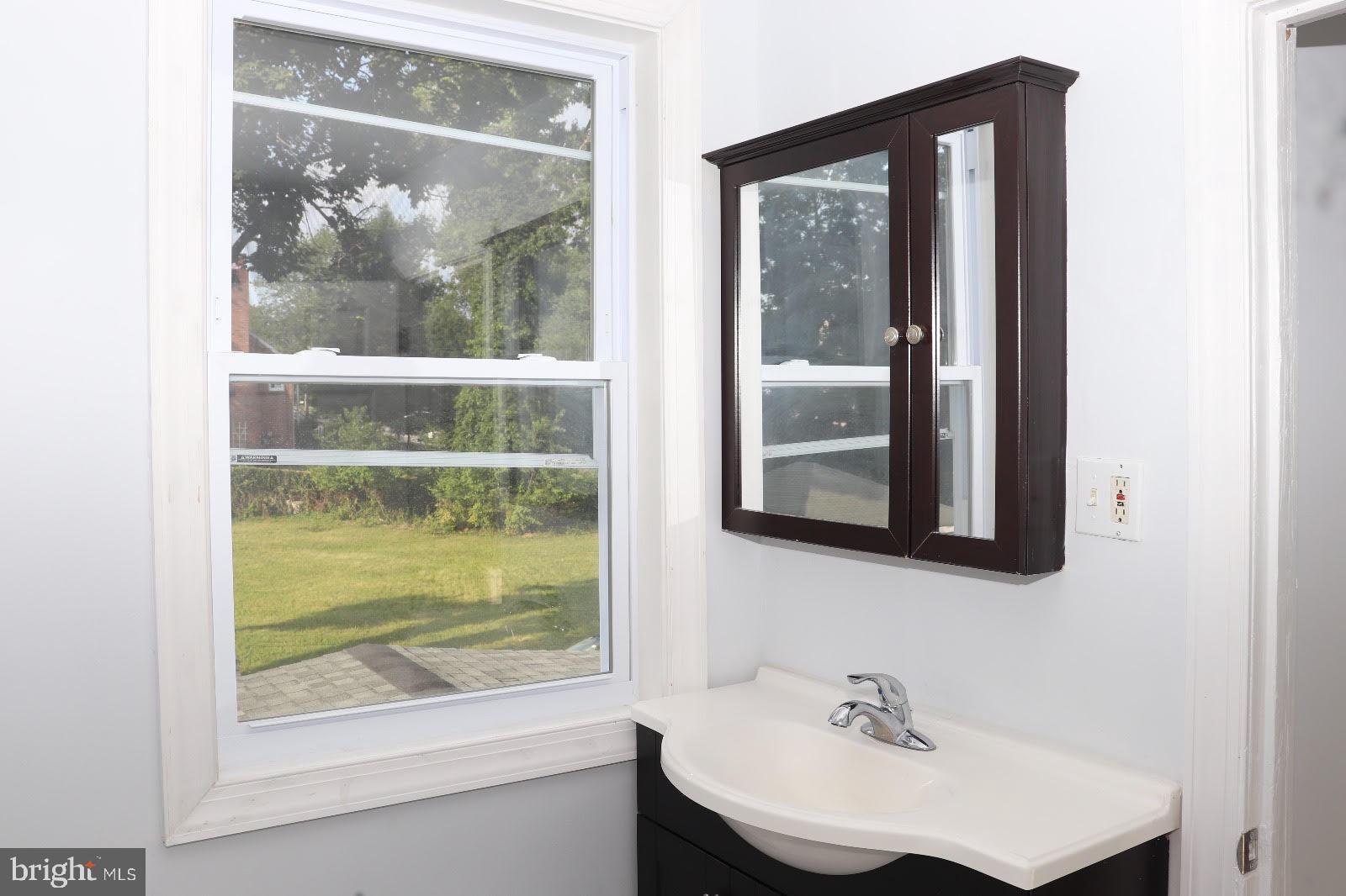 8400 Liberty Road Baltimore, MD 21244 - Photo 10 of 32 a bathroom with a sink mirror and a window
