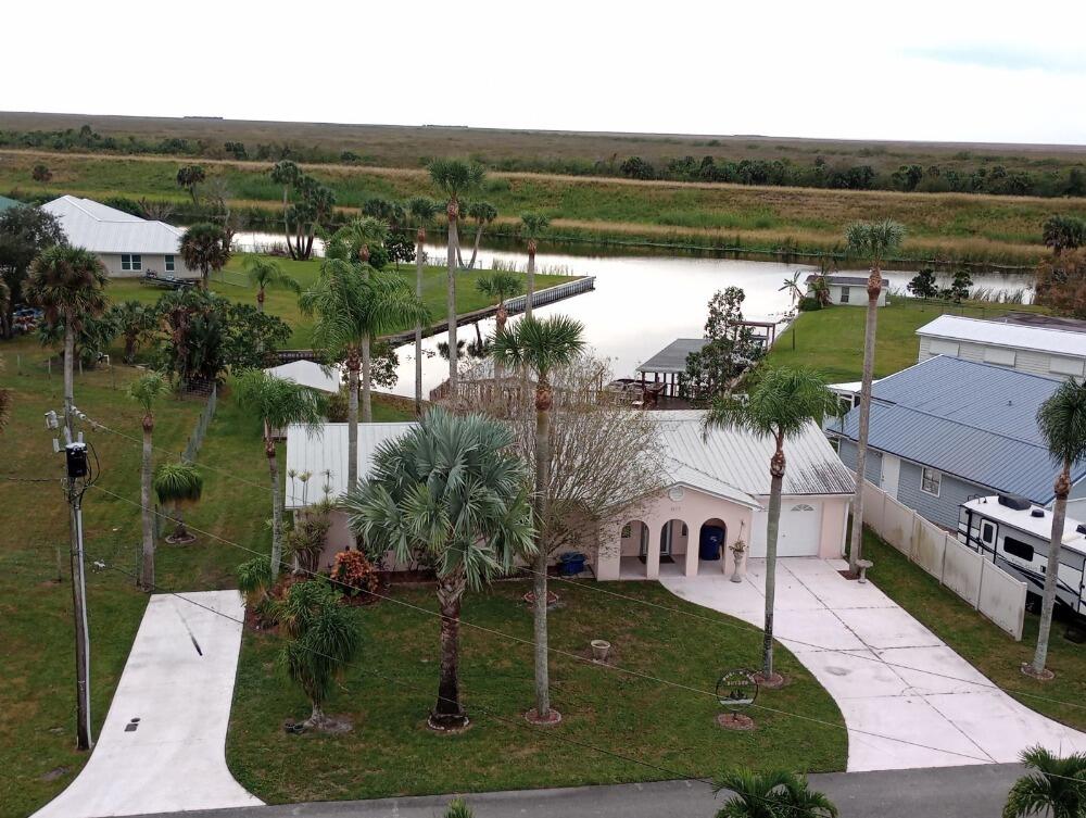 an aerial view of a house with a yard lake view and mountain view in back