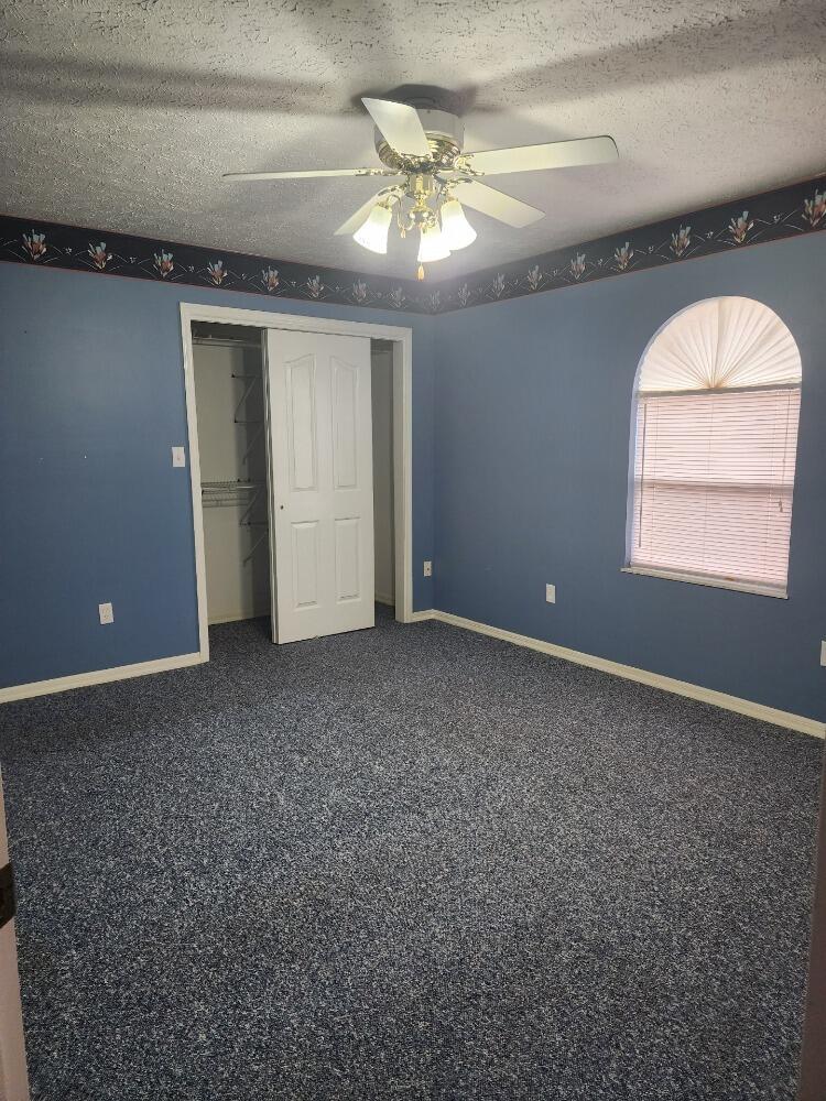 1177 Lisa Lane Okeechobee, FL 34974 - Photo 13 of 22 en empty room with windows and fan