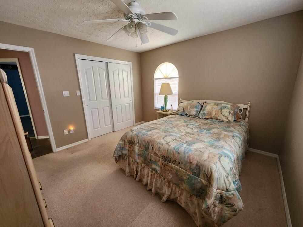 1177 Lisa Lane Okeechobee, FL 34974 - Photo 14 of 22 a bedroom with a bed and a chandelier