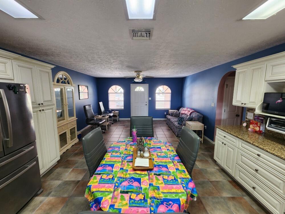 1177 Lisa Lane Okeechobee, FL 34974 - Photo 4 of 22 a very nice looking open kitchen with stainless steel appliances granite countertop a dining table and chairs in it