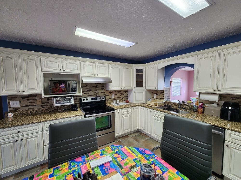 1177 Lisa Lane Okeechobee, FL 34974 - Photo 5 of 22 a kitchen with stainless steel appliances granite countertop a sink stove and microwave