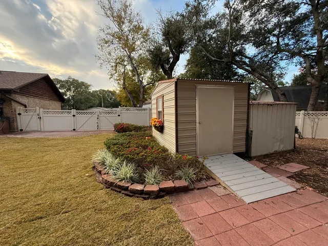 a view of a house with big yard and large tree