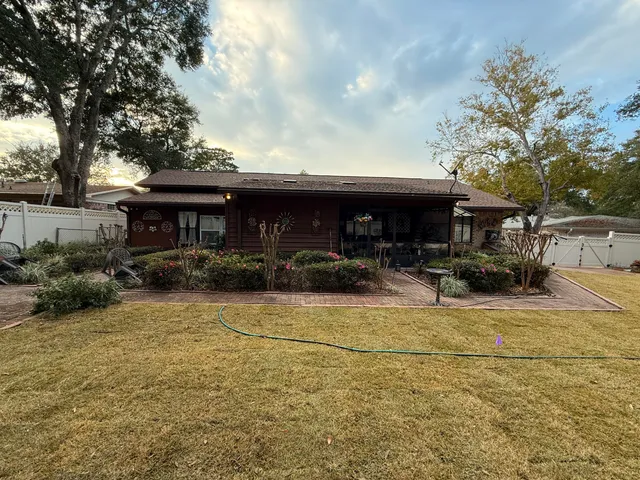 a view of the patio with dining table and chairs under an umbrella