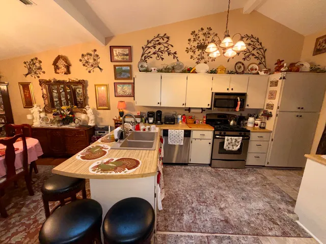 a kitchen with a stove a table and chairs in it