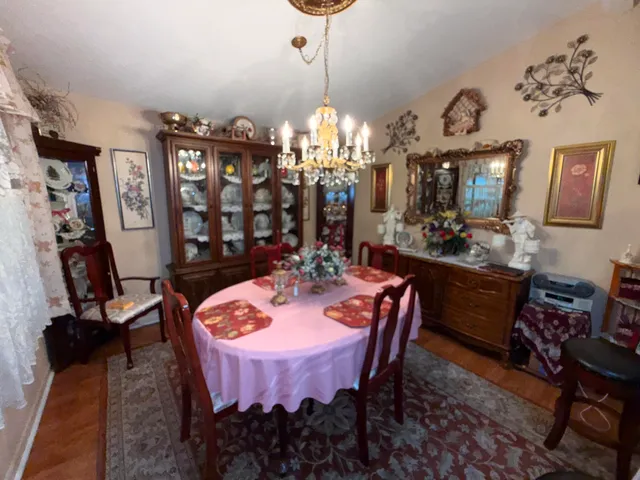 a dining room with furniture a chandelier and window
