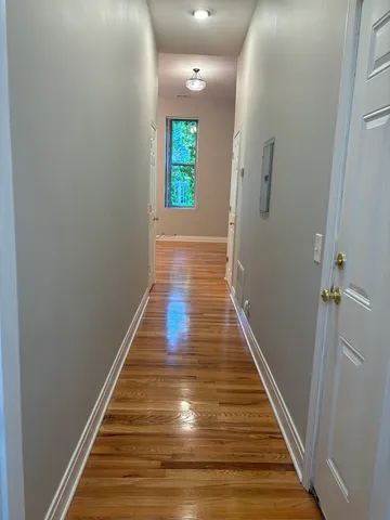 a view of a hallway with wooden floor and staircase