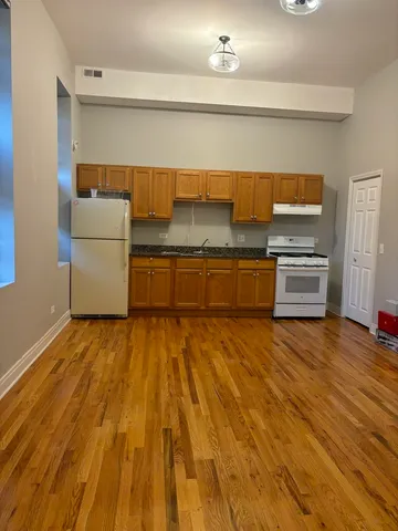 a kitchen with granite countertop a stove and a refrigerator