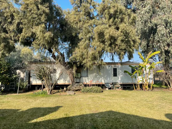 a front view of residential houses with yard and trees