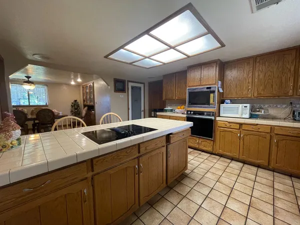 a kitchen with stainless steel appliances granite countertop a sink a stove a microwave a counter top space and cabinets