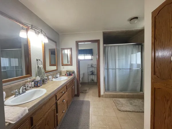 a spacious bathroom with a double vanity sink and a mirror