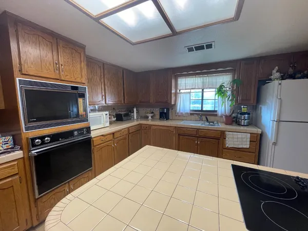 a kitchen with a sink a stove top oven and refrigerator