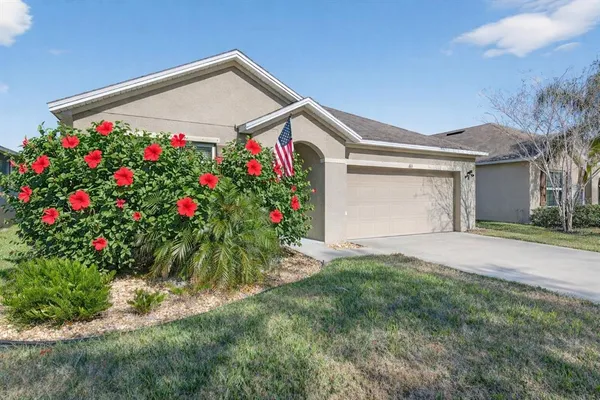 a front view of a house with a yard and fountain
